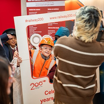 Golygfa agos o'r plant yn cael eu llun wedi'i dynnu rhwng ffrâm gyda'r geiriau Celebrating 200 Years of Train