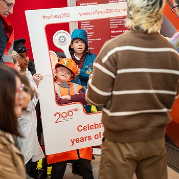 Plant yn cael eu llun wedi'i dynnu rhwng ffrâm gyda'r geiriau Celebrating 200 Years of Train