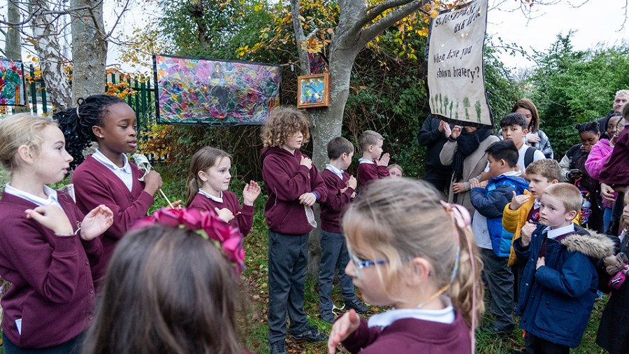 students in a garden with artworking hanging up