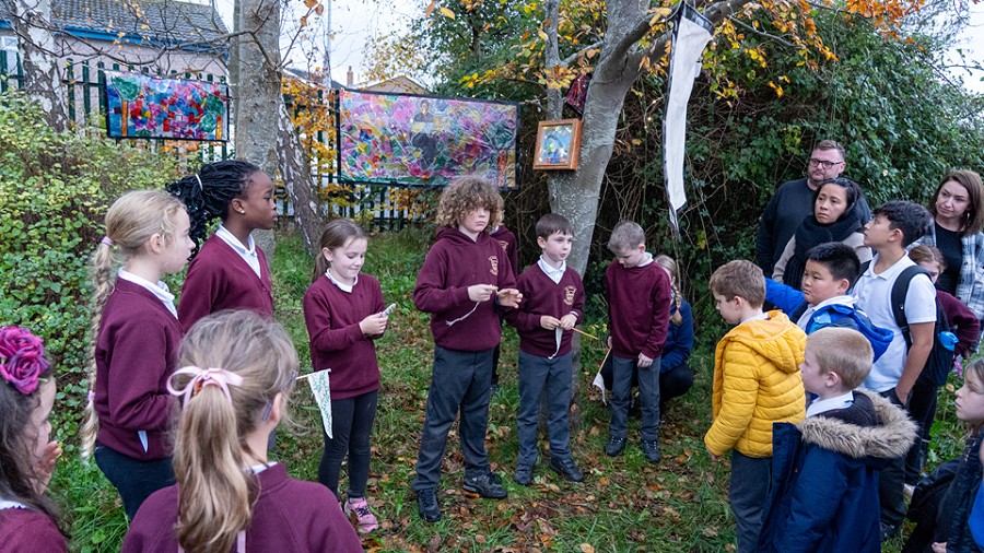 students standing outside next to the artwork
